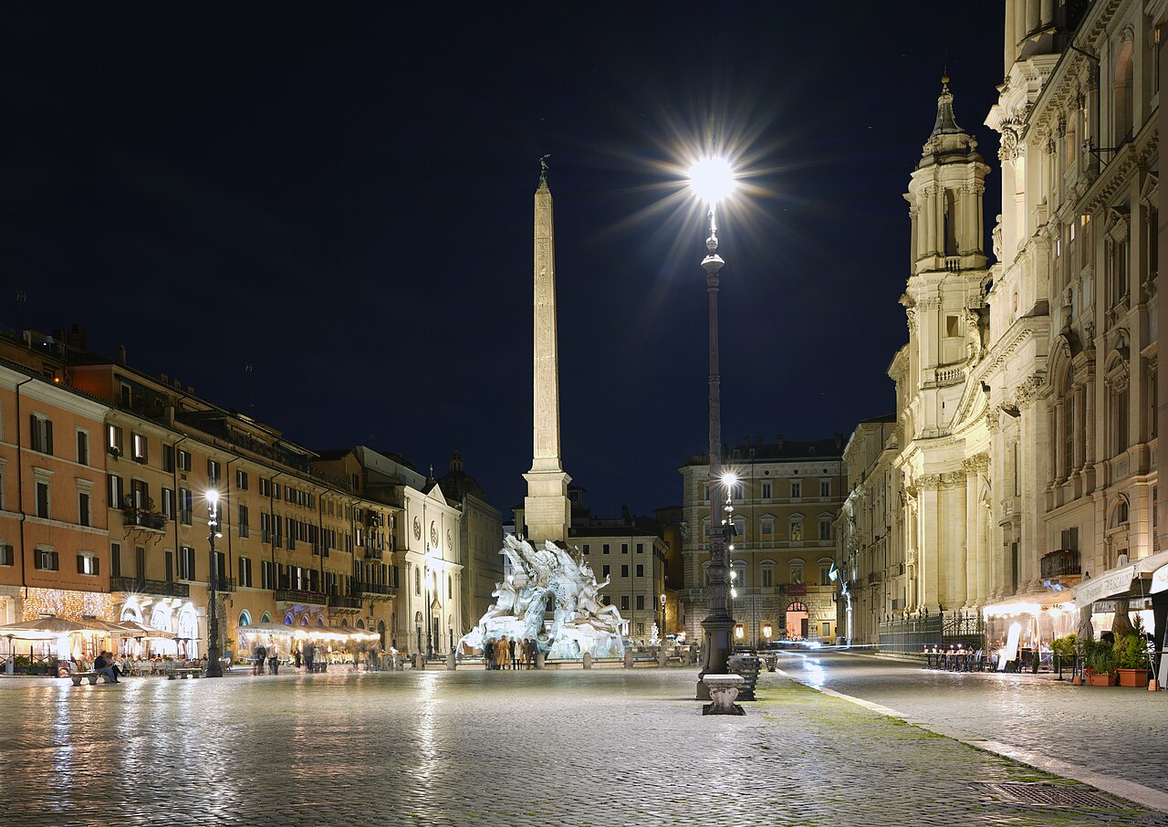 Piazza Navona at night with fountains and city lights